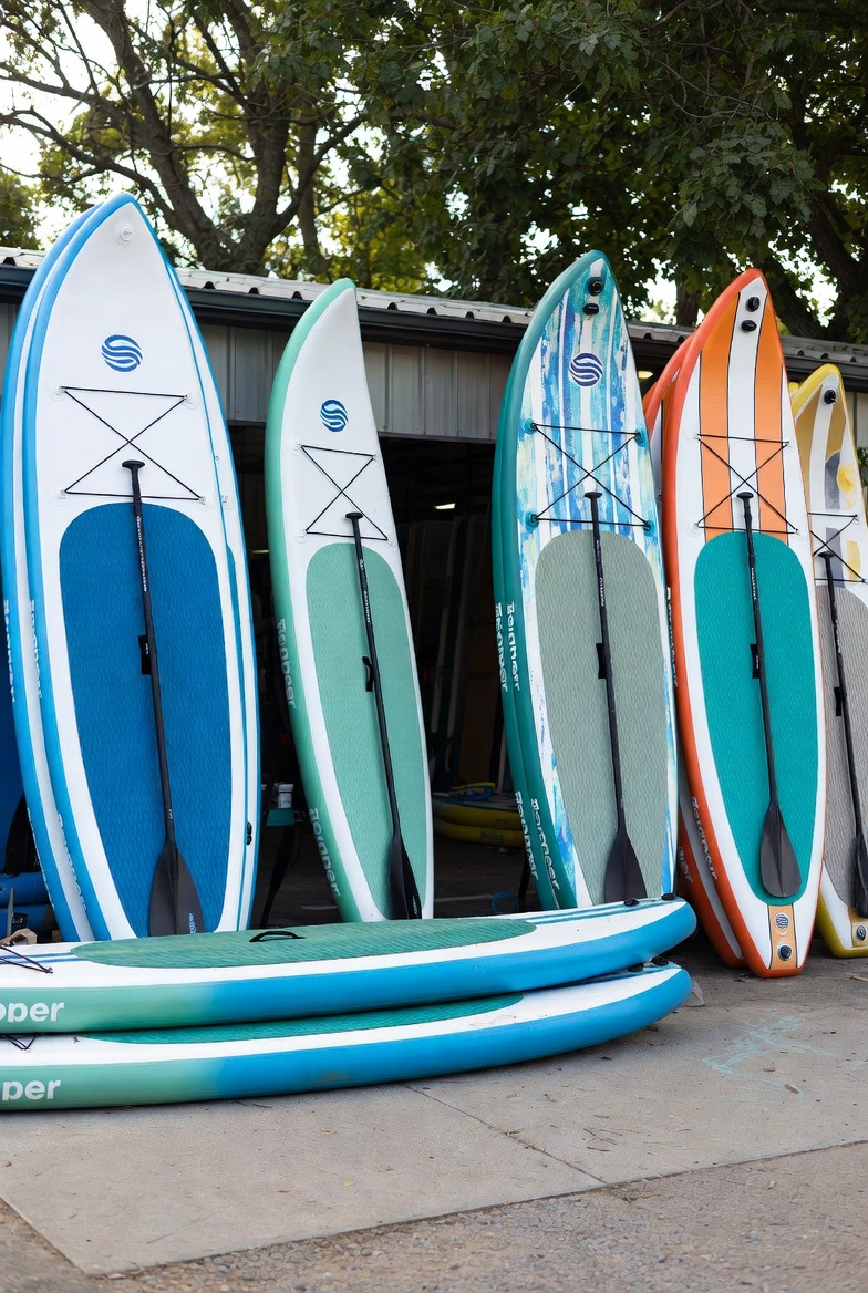 Colourful stand-up paddleboards lined up and ready to rent